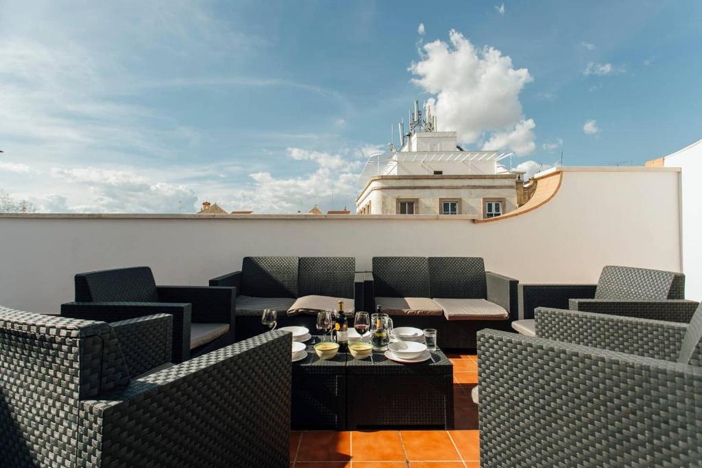 een patio met stoelen en een tafel en een gebouw bij Duplex with terrace- 5Bd 3Bth- Center in Sevilla