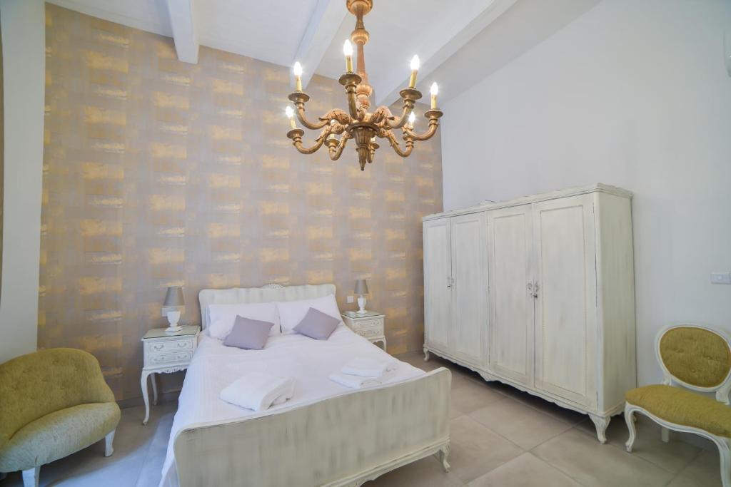 1 dormitorio con cama y lámpara de araña en CA2- City Central Apartment 2, en Floriana