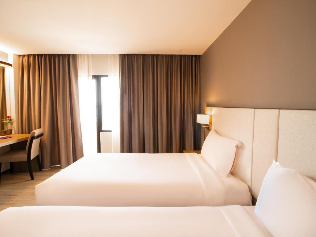 Postel nebo postele na pokoji v ubytování Fortune View Khong Hotel Nakhon Phanom