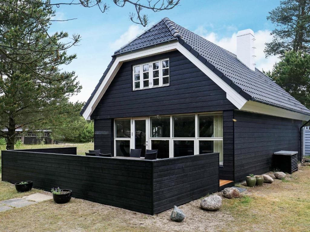 Mosevrå的住宿－Holiday Home Grævlingevej II，一间设有许多窗户的黑色房子