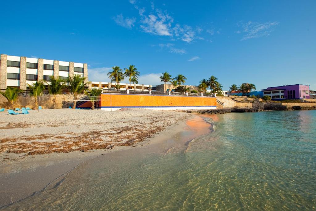 una playa con edificios, palmeras y agua en Hotel Tucan Siho Playa, en Sihoplaya