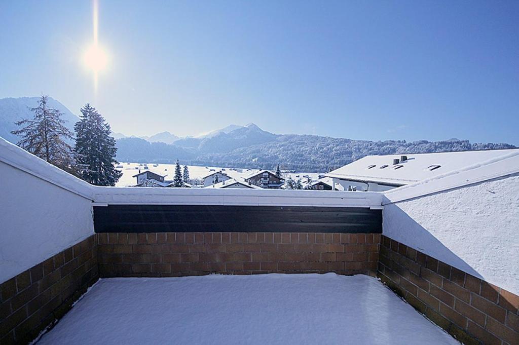 pokryty śniegiem dach domu z pokrytym śniegiem dachem w obiekcie Ferienwohnungen Wolter w mieście Oberstdorf