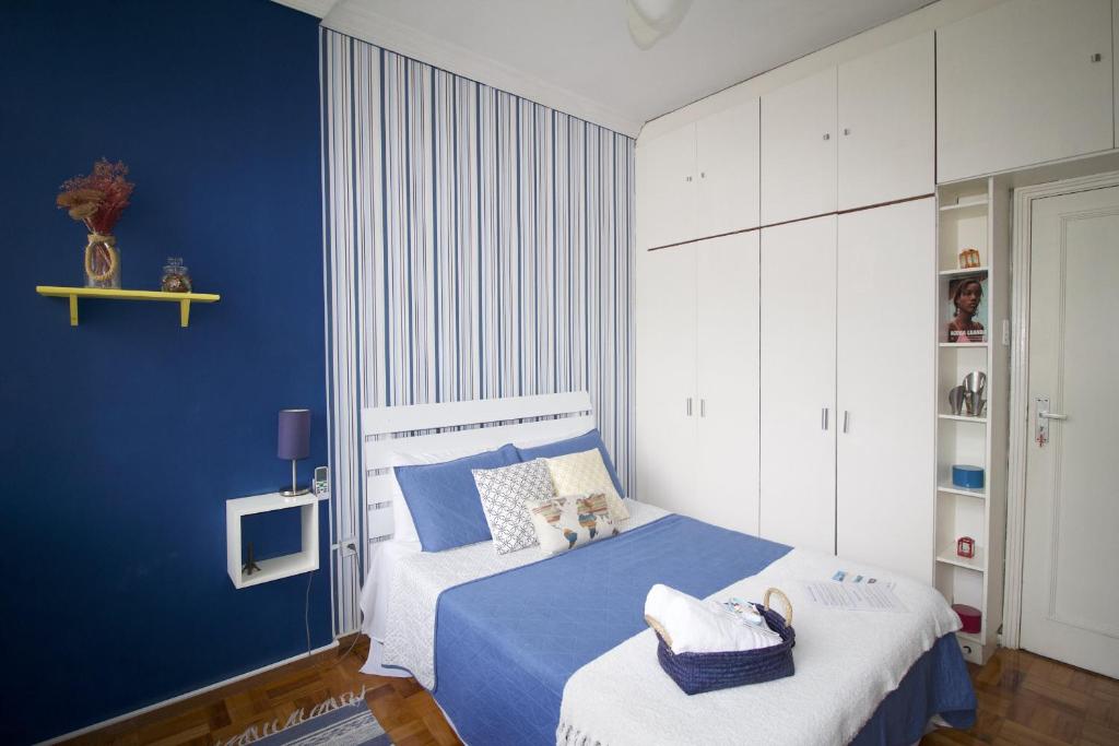1 dormitorio azul con 1 cama con pared azul en LGBT Friendly - Quarto em Ipanema Posto 9 - Casa de Vitor e Carlos, en Río de Janeiro