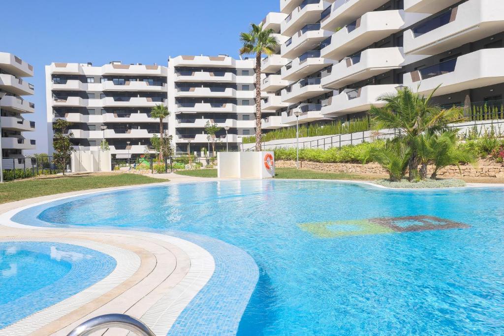 basen przed dużym budynkiem mieszkalnym w obiekcie MyFlats Luxury Arenales w mieście Arenales del Sol