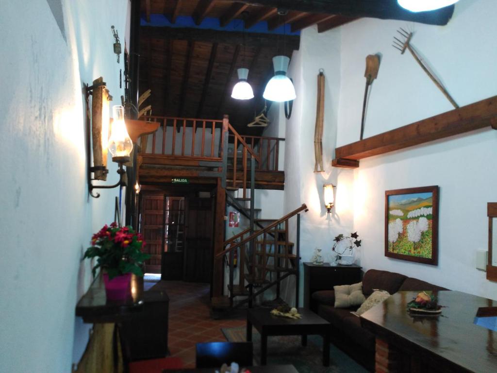 a living room with a spiral staircase in a house at Room El Pilarillo in Alcaucín