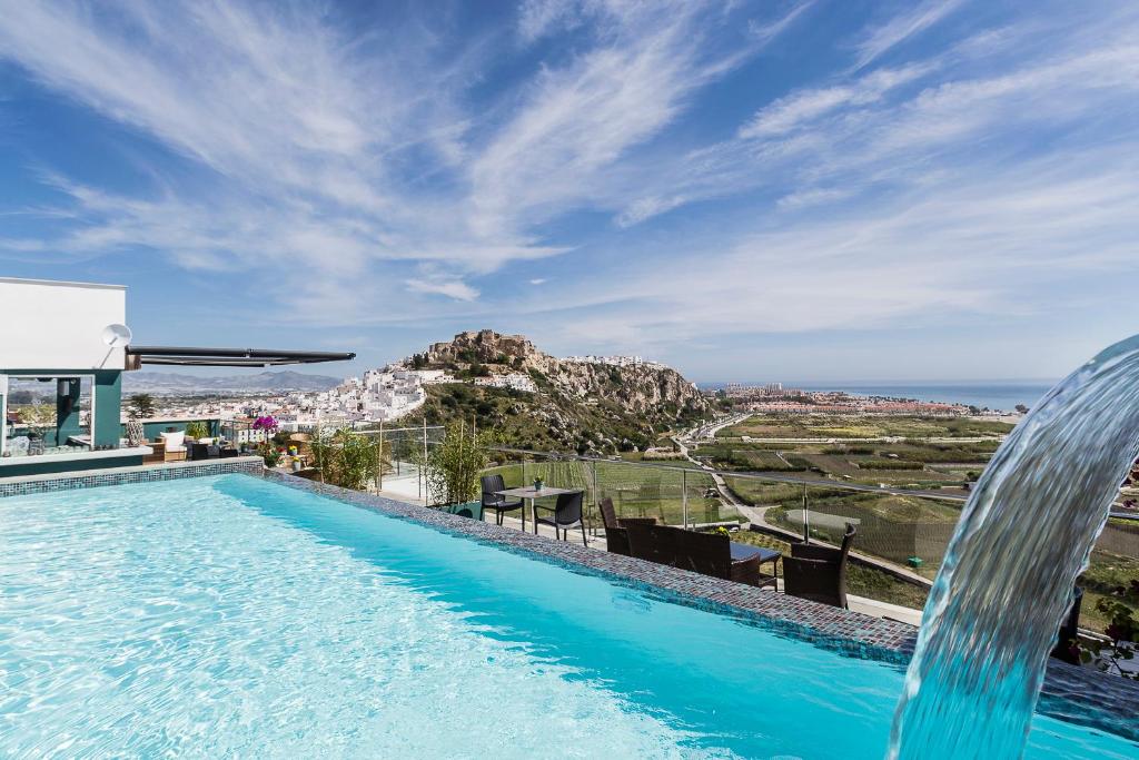 a large swimming pool with a balcony overlooking the ocean at Hotel Miba in Salobreña