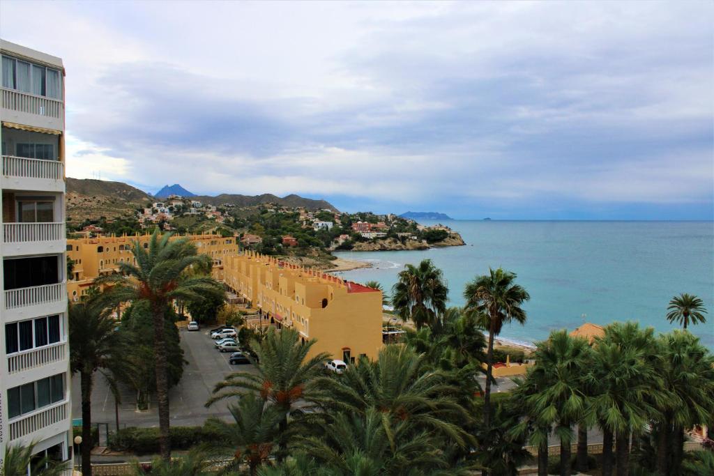 a view of a resort with palm trees and the ocean at Piso con vistas al mar El Campello in El Campello