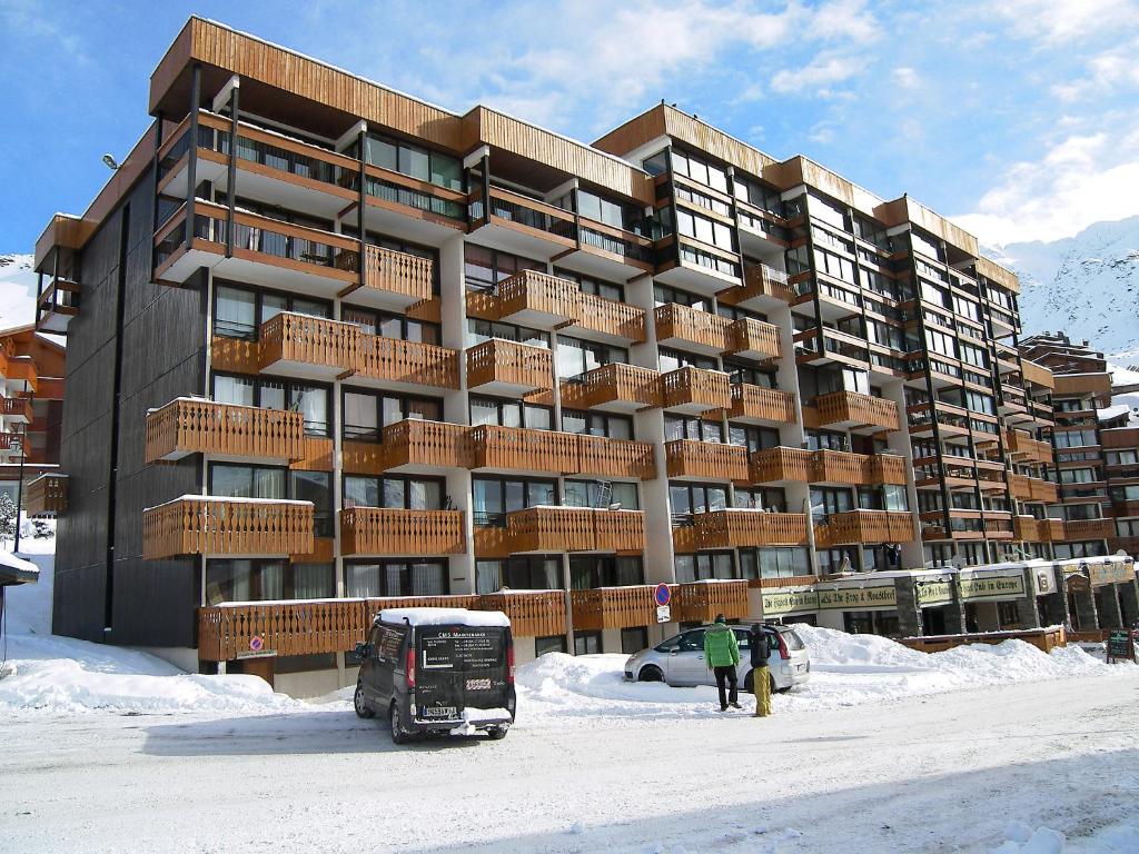a large building in the snow with people walking in front of it at Apartment Neves-5 by Interhome in Val Thorens