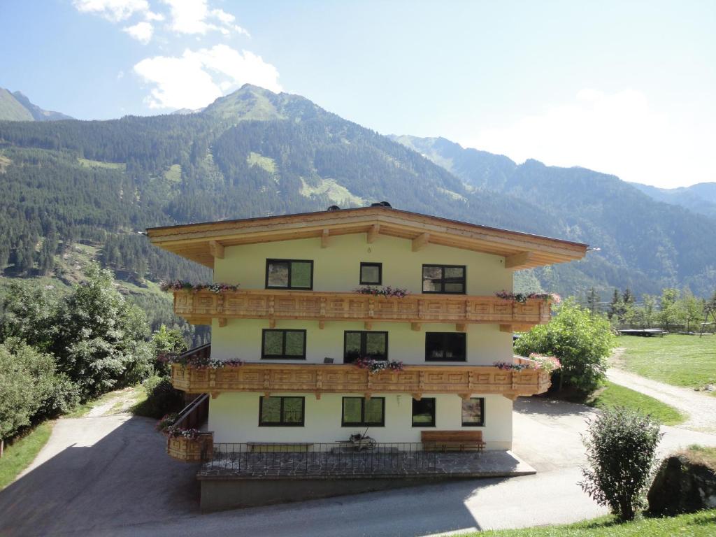 ein Gebäude auf einem Hügel mit Bergen im Hintergrund in der Unterkunft Ferienwohnung - Schmirnerhof in Brandberg