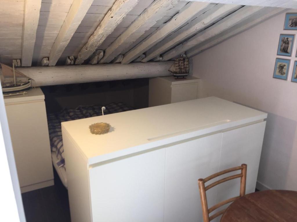 Una pequeña nevera blanca en una habitación con mesa en La Trabacca, attico nel pieno centro di Levanto, en Levanto