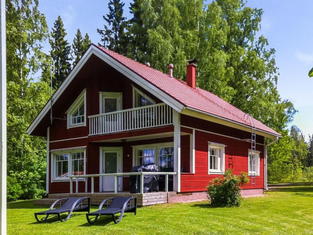 a red house with chairs in front of it at Holiday Home Lauttavalkama by Interhome in Torvoila