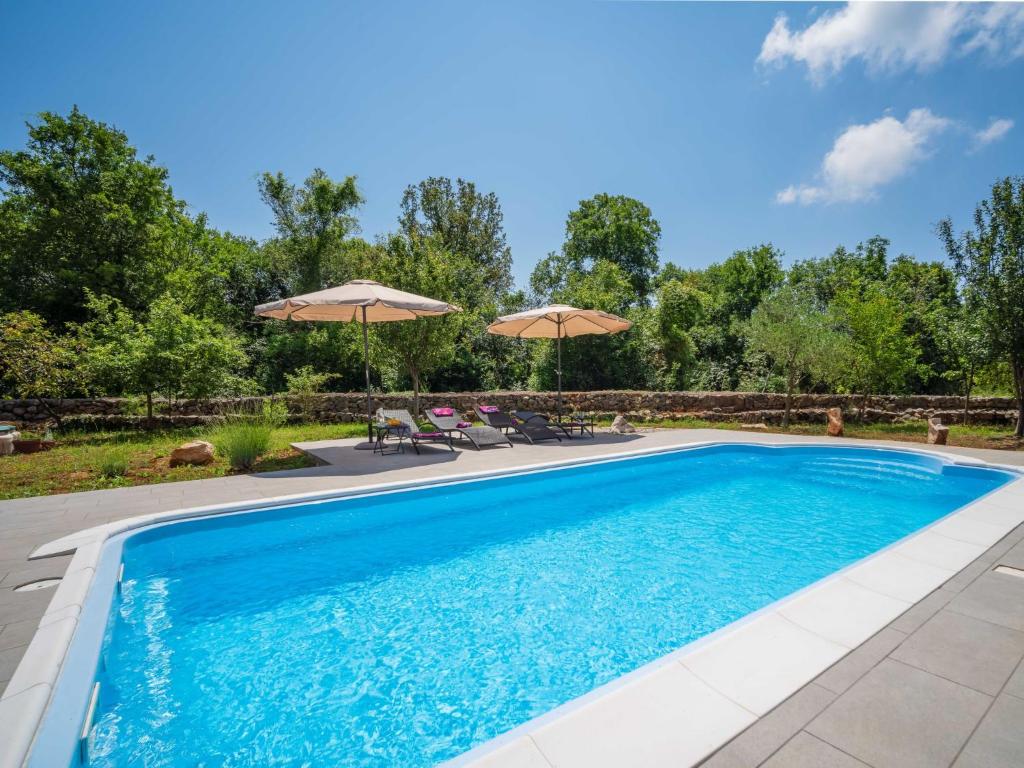 una piscina con acqua blu e ombrelloni di Holiday Home Mila by Interhome a Kras