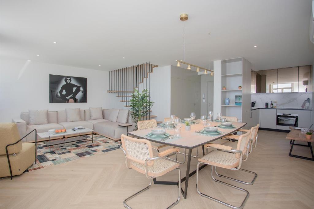a dining room and living room with a table and chairs at Liiiving in Porto - Luxury Beachfront Apartments in Porto