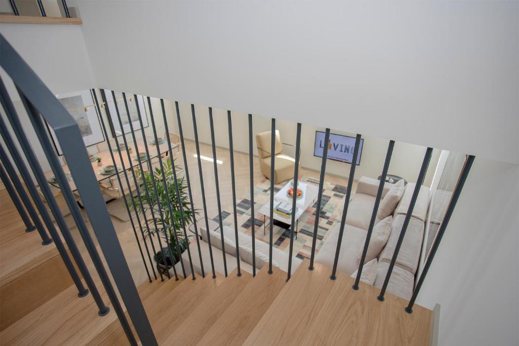 a staircase with a metal railing next to a room at Liiiving in Porto - Luxury Beachfront Apartments in Porto