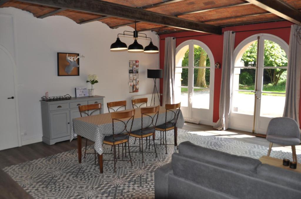 a living room with a table and chairs and a couch at Au Rez de Jardin in Cholet