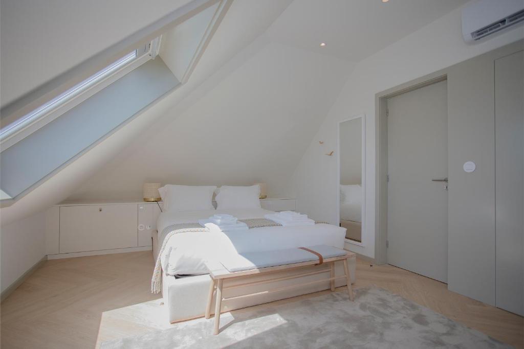 a white bedroom with a bed and a staircase at Liiiving in Porto - Luxury Beachfront Apartments in Porto