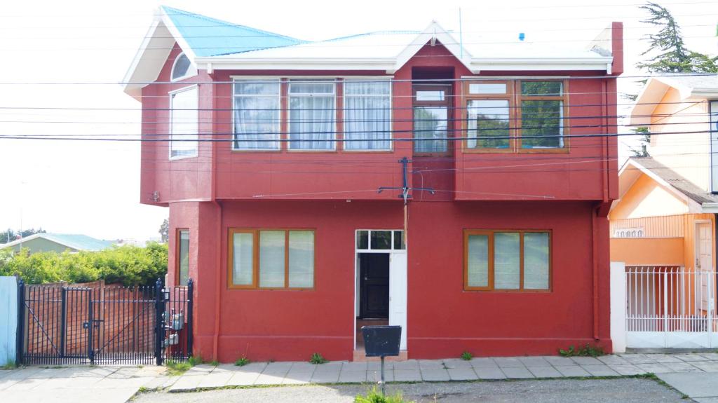 a red house with a white door at Haiken Hostal in Punta Arenas
