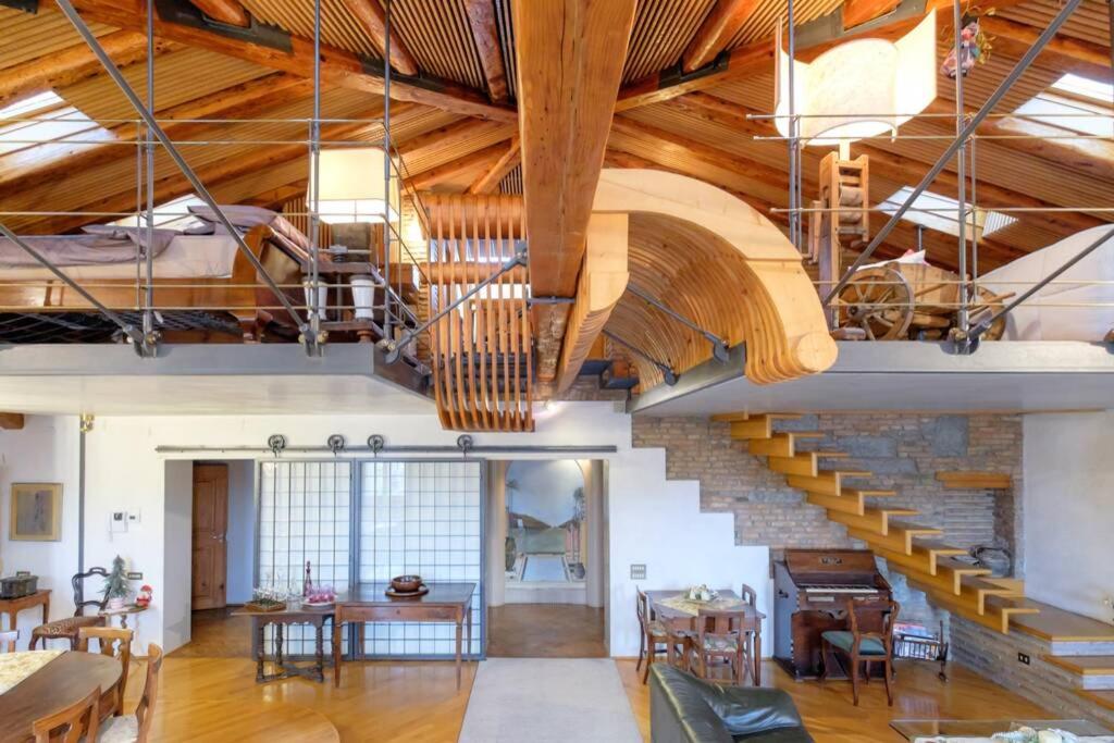 Habitación grande con techos de madera y escalera. en 6 Ponterosso - Luxury Attic, en Trieste