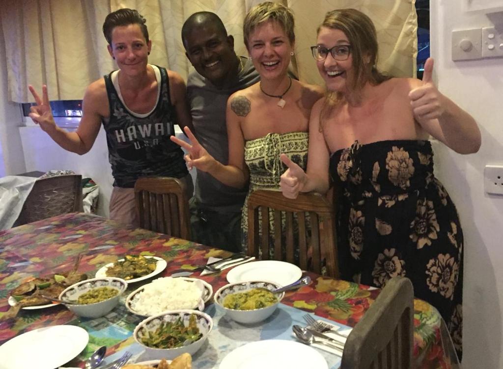 grupa ludzi stojących przy stole z jedzeniem w obiekcie Anna Tourist Inn w Negombo