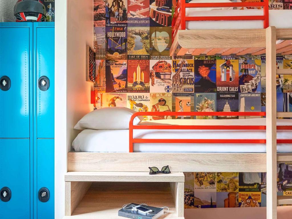 a bedroom with a bunk bed with a wall covered in posters at hotelF1 Strasbourg Pont de l'Europe in Strasbourg