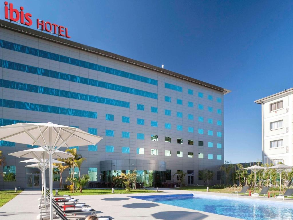 a hotel with a pool in front of a building at Ibis Antananarivo Ankorondrano in Antananarivo