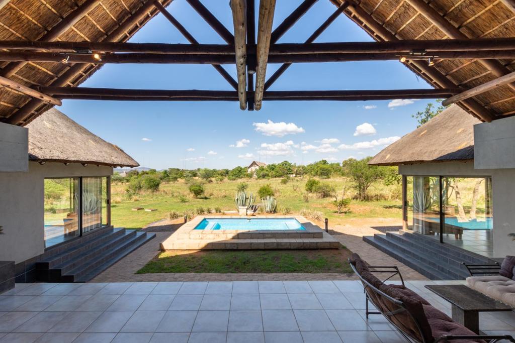 a view of the pool from the patio of a villa at Zebula - HT1 - 5 Bedroom Holiday Home in Mabula