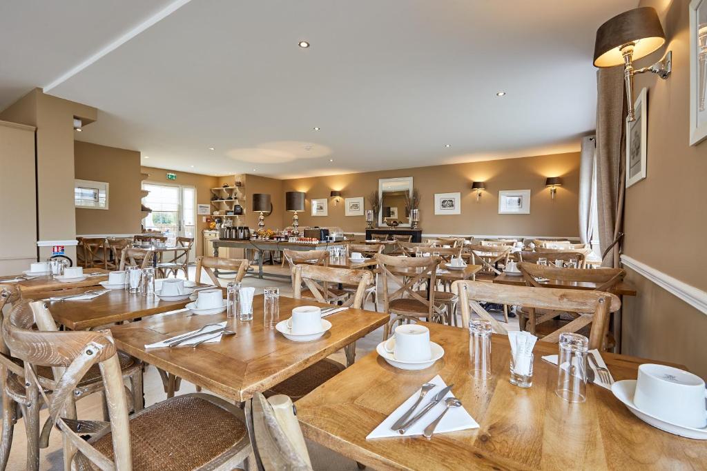 a dining room with wooden tables and chairs at Les Villas d'Arromanches, Teritoria in Arromanches-les-Bains