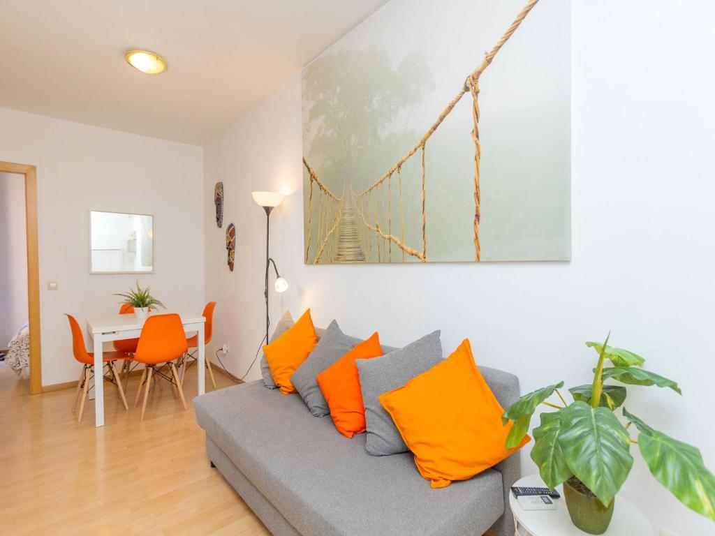 a living room with a couch with orange pillows at Apartment Eixample Dret Sagrada Familia by Interhome in Barcelona