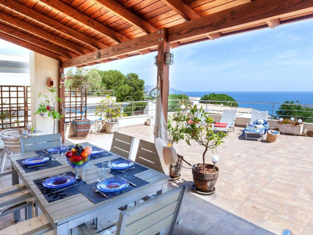 a table on a patio with a view of the ocean at Apartment Fane De Baix I by Interhome in Llança