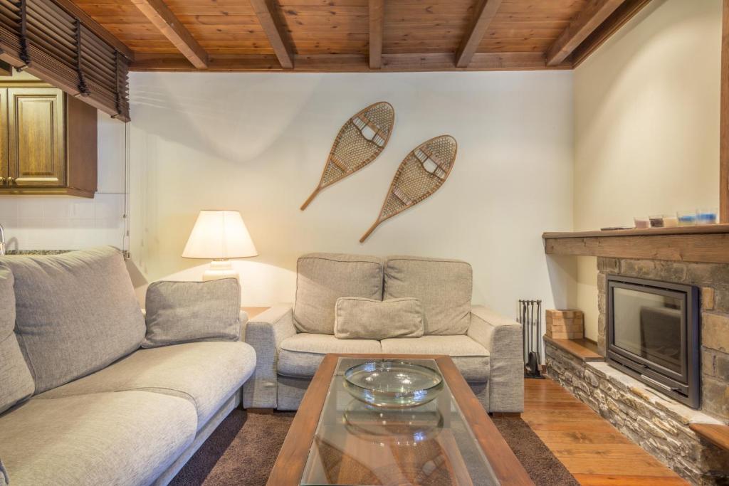 Una sala de estar con dos sofás y una chimenea. en Jordana by Totiaran, en Baqueira Beret