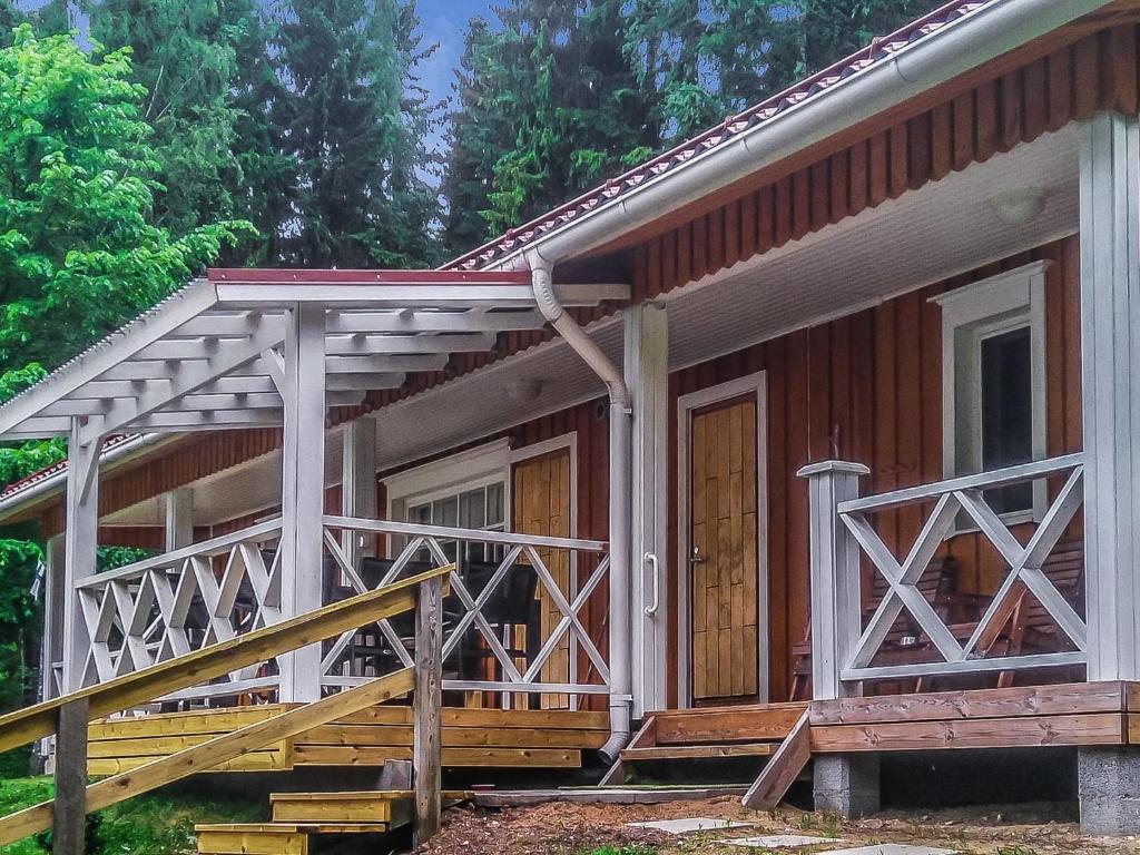 a small house with a porch and a wooden staircase at Holiday Home Villa siesta by Interhome in Torvoila