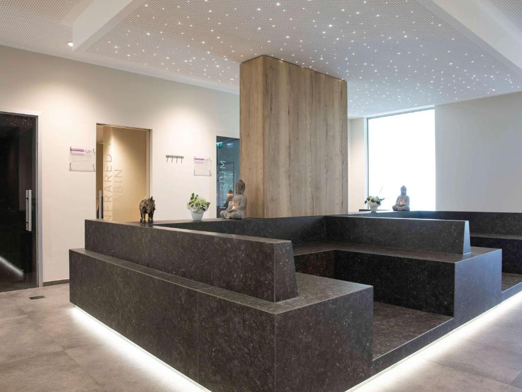 a lobby with a counter with a dog on it at Mercure Luxembourg Kikuoka Golf & Spa in Canach