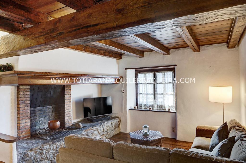 sala de estar con sofá y chimenea en Apartamento Era Cascada By Totiaran, en Baqueira Beret