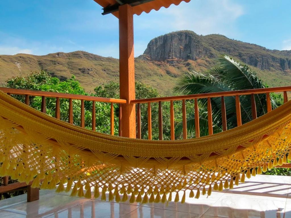 a hammock on a porch with a view of a mountain at Pousada Rancho dos Ipês in Alto Paraíso de Goiás