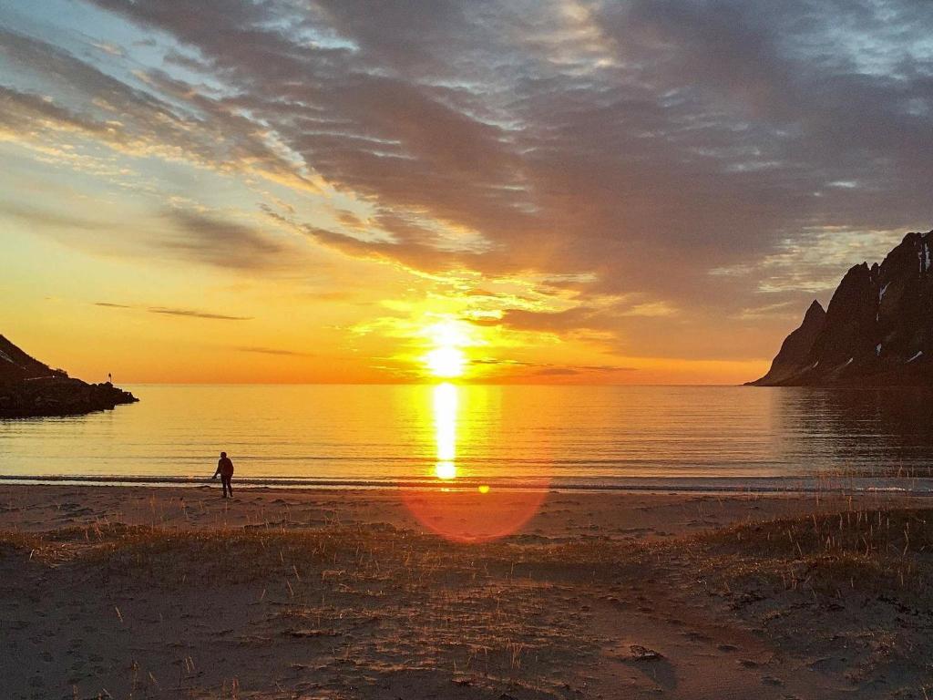 une personne se promenant sur la plage au coucher du soleil dans l'établissement 6 person holiday home in Senjahopen, à Mefjordvær