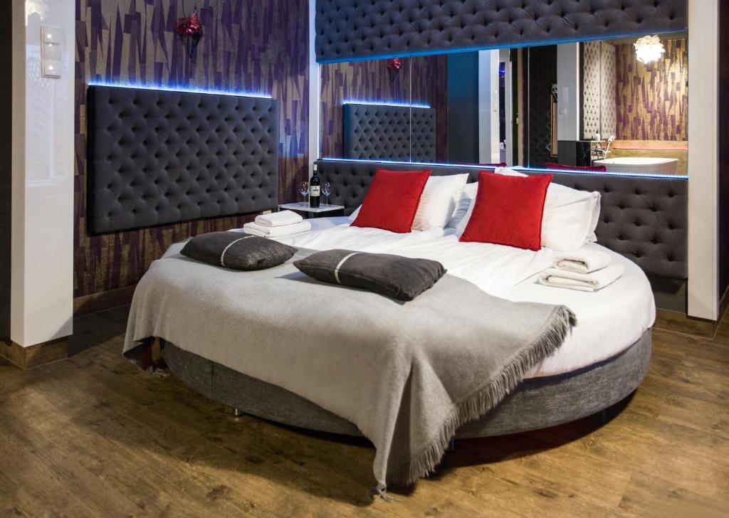een groot bed met rode kussens in een kamer bij Yourplace Romantic Apartment with private patio in Krakau