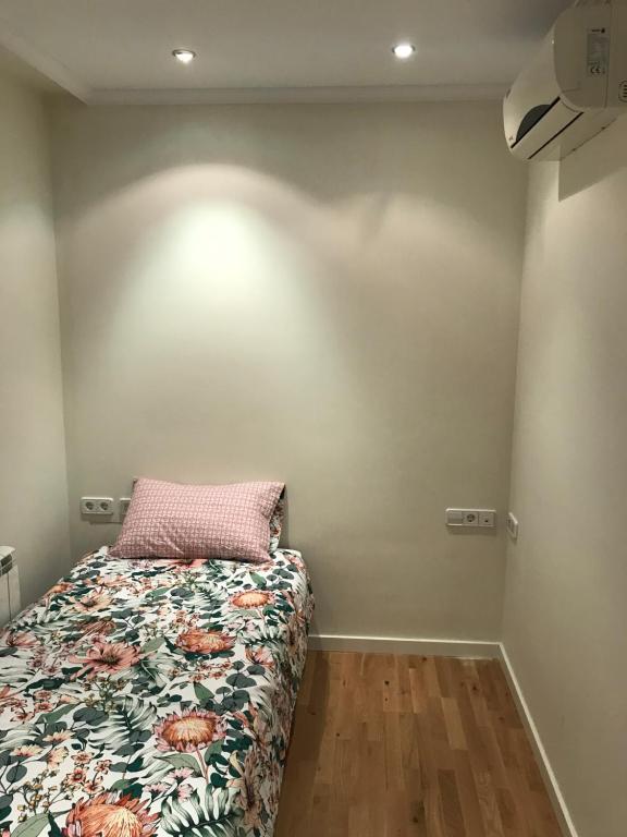 sypialnia z łóżkiem z kołdrą kwiatową w obiekcie Casa Duquesa w mieście Logroño