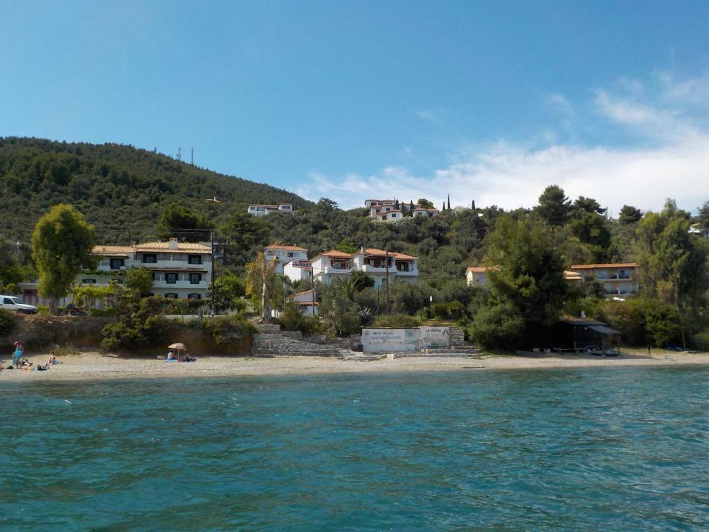 a beach with houses on a hill next to the water at Azalea in Megali Ammos