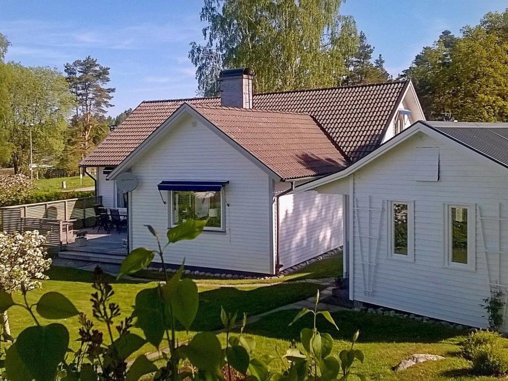 een wit huis met een veranda en een tuin bij 8 person holiday home in LERUM in Lerum