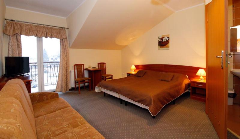 pokój hotelowy z łóżkiem i kanapą w obiekcie Pokoje Maria w Kudowie Zdroju