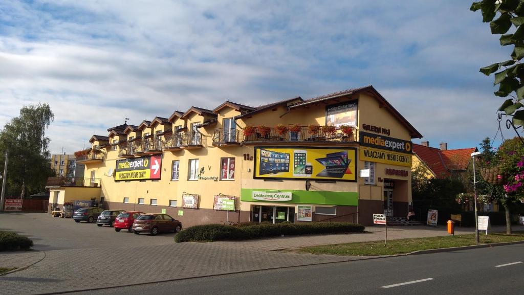 duży budynek z samochodami zaparkowanymi przed nim w obiekcie Pokoje Maria w Kudowie Zdroju