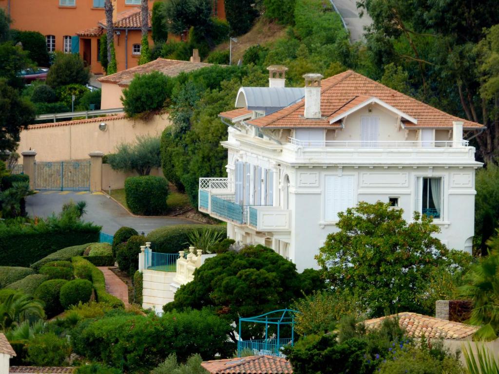 a white house on a hill with bushes and trees at Toi & Moi in Sainte-Maxime