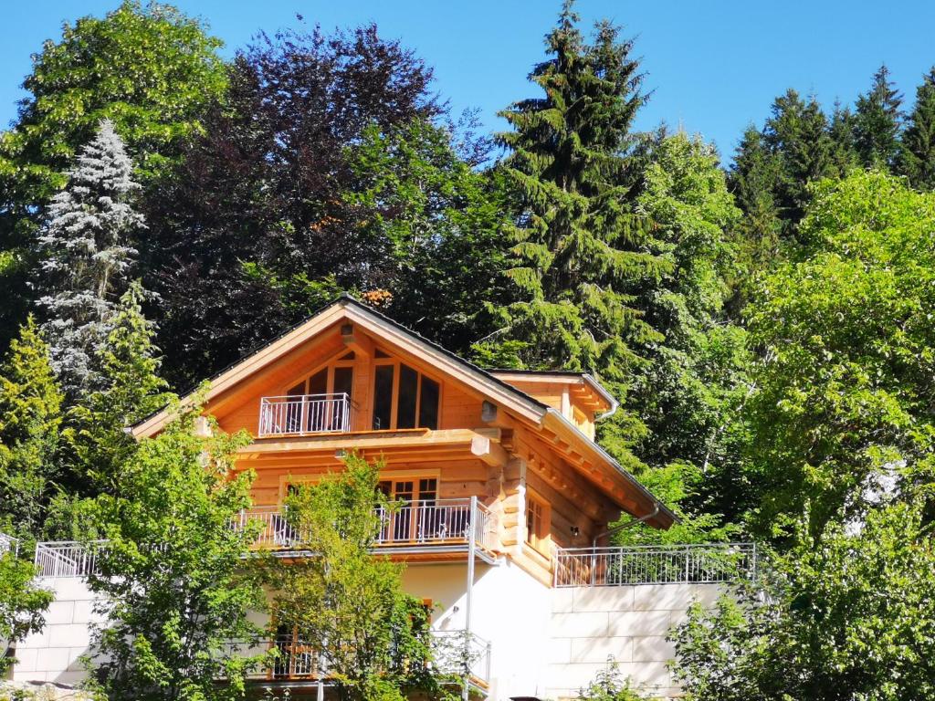 una cabaña de madera en el bosque con árboles en Ferienhaus Chalet-Ettal en Ettal