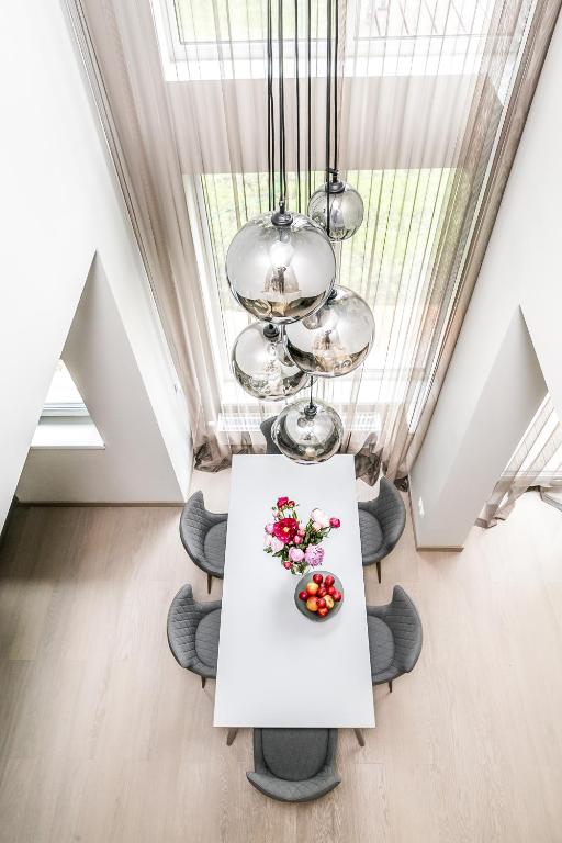 a white table with flowers on it in a room at Imanta Garden Townhouses in Riga