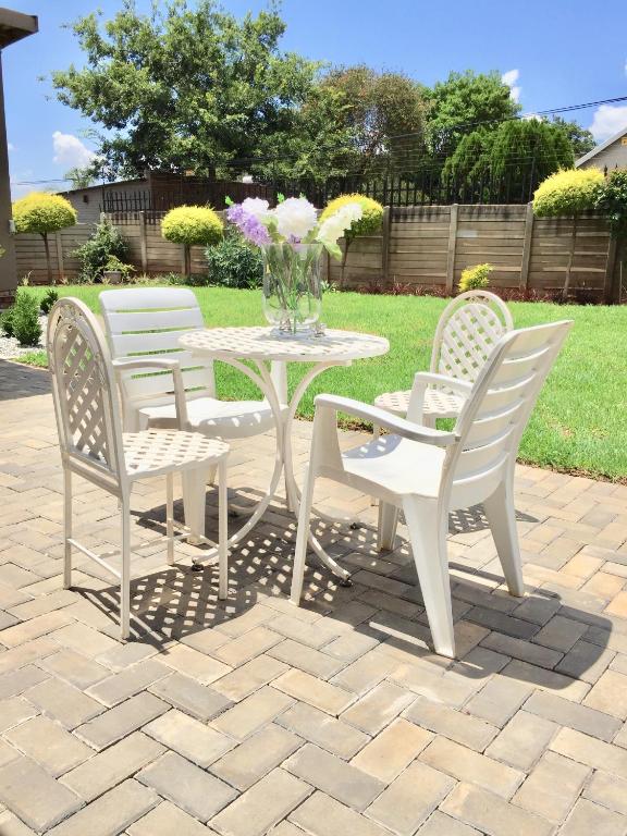 a white table and chairs on a brick patio at African Kingdom Guest House in Boksburg