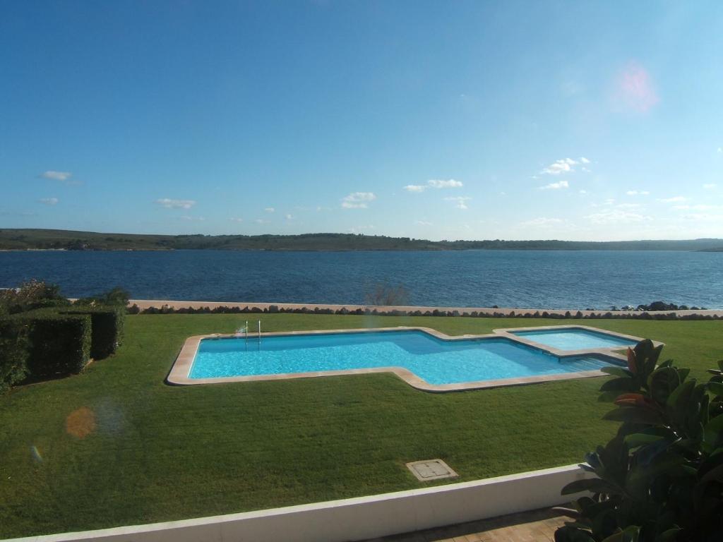 una piscina accanto a un bacino d'acqua di ES CASTELL 1 6 by SOM Menorca a Fornells