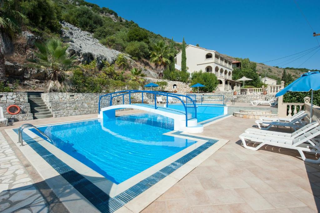 uma grande piscina com uma ponte sobre ela em Dimitrios Apartments em Kassiopi