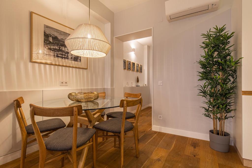 una sala da pranzo con tavolo, sedie e una pianta in vaso di Upscale & Modern 2BDR Apartment a Lisbona