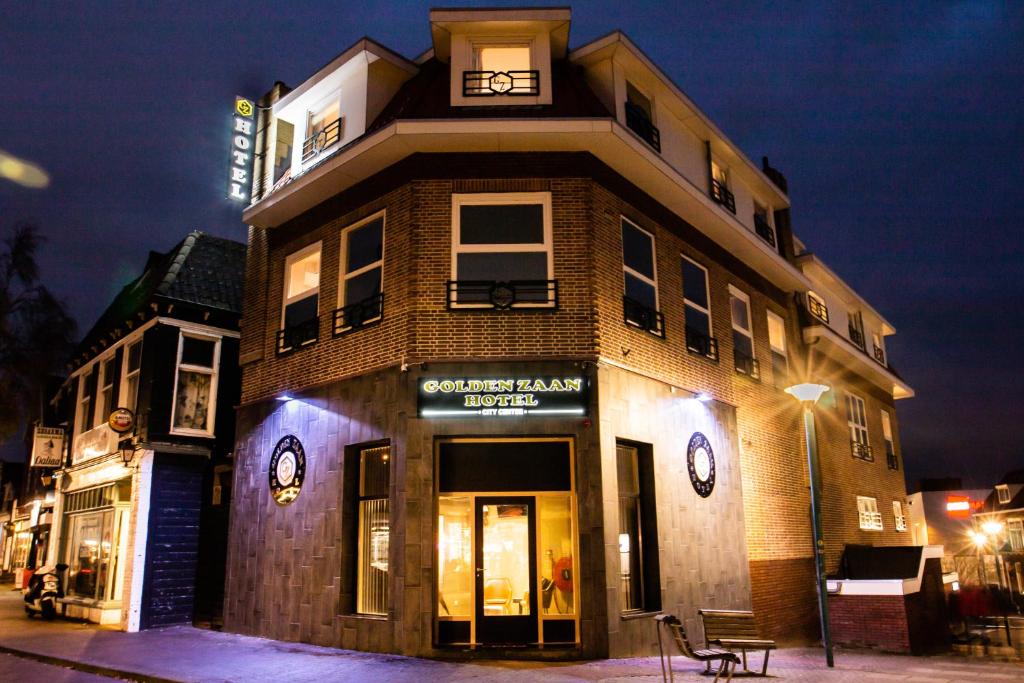 um edifício de tijolos alto com um restaurante numa rua em Golden Zaan Hotel, Zaandam-Amsterdam em Zaandam