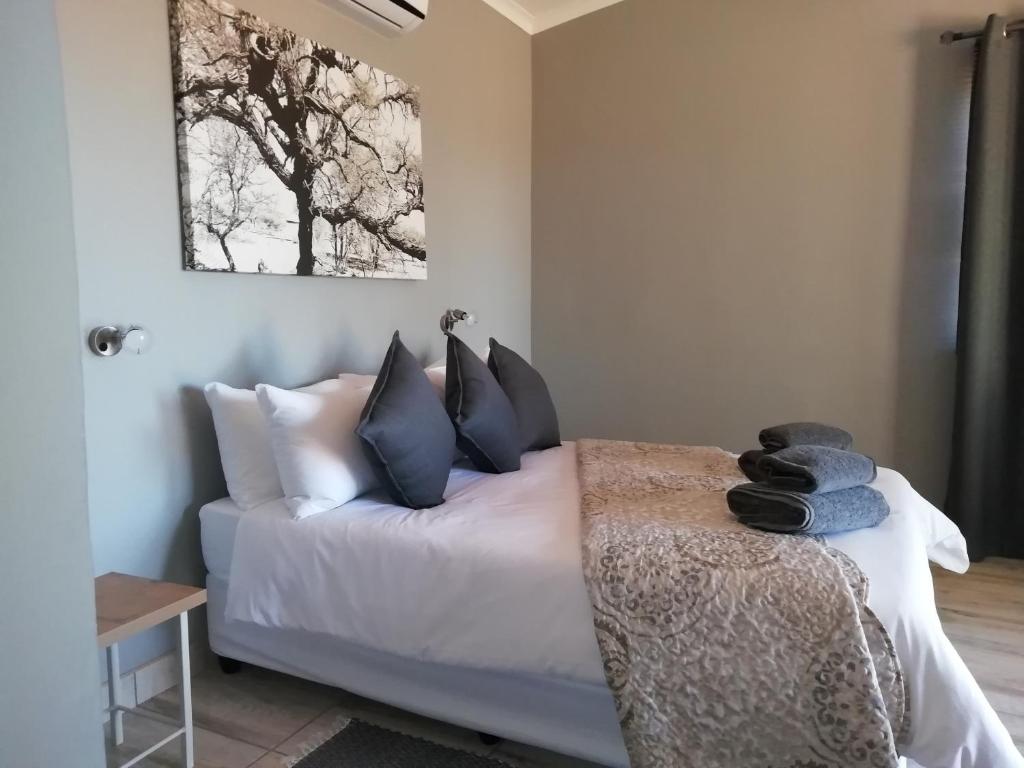 Schlafzimmer mit einem Bett mit schwarzen und weißen Kissen in der Unterkunft Jansen Kalahari Guest Farm in Hoachanas